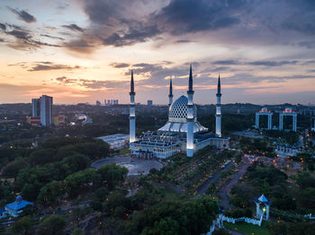 Modern buildings in city against sky during sunset