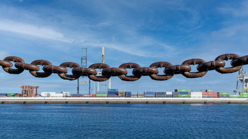 Chain on sea against sky in city