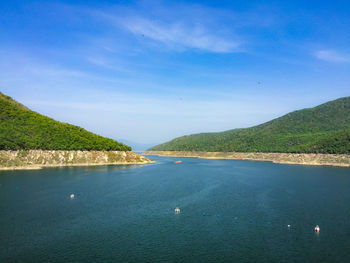 Scenic view of sea and mountains against sky