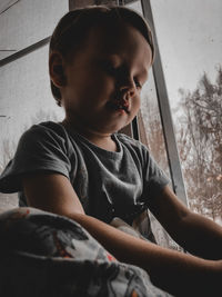 Portrait of boy looking through window