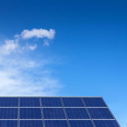 Low angle view of solar panels against blue sky