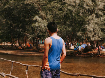 Rear view of man standing against trees