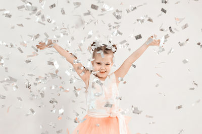 Portrait of cheerful girl standing against white background