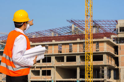 Male engineer pointing at construction site