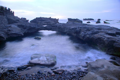 Rocks on sea shore against sky