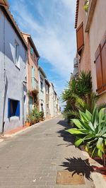 Alley amidst buildings in city against sky