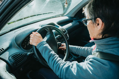 Woman turning on ignition switch of car