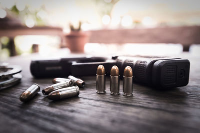 Close-up of handgun with bullets on table