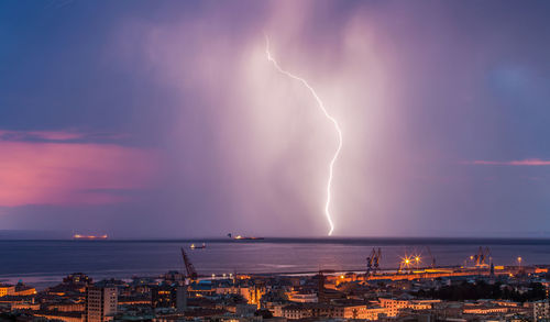 Panoramic view of lightning over city at night