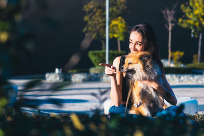 Woman with dog sitting at park