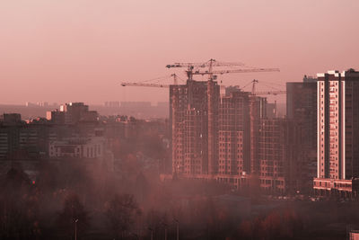 Buildings in city against sky during sunset