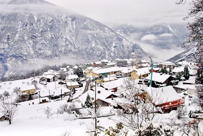 Snow covered land and mountains against sky