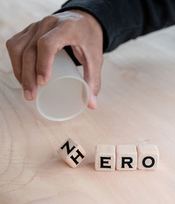 High angle view of hand holding coffee cup on table