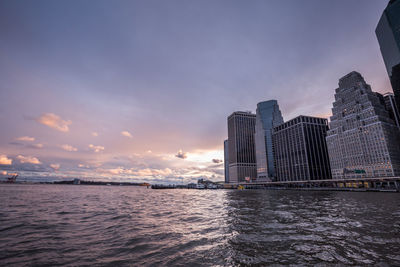 Sea by cityscape against sky