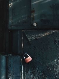 Close-up of padlock hanging on old door