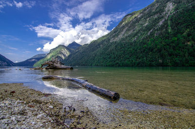 Scenic view of lake by mountain against sky