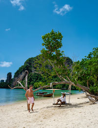 People at beach against sky