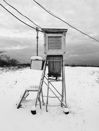 Built structure on snow covered field against sky