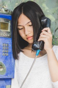Close up portrait of beautiful girls use classic public phone booths old communication, technology.