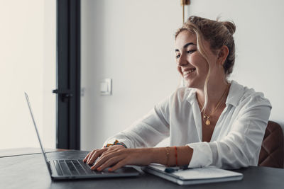 Businesswoman using laptop while sitting on table