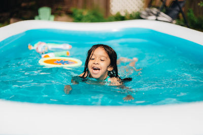 Portrait of young woman swimming in pool