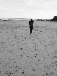 Rear view of man walking on beach