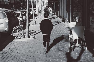 Rear view of woman walking on street in city