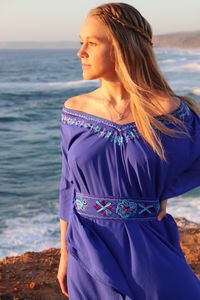 Young woman looking away while standing on beach