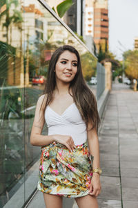 Portrait of smiling young woman standing outdoors