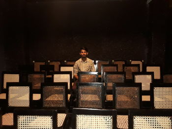 Young man sitting on chair at movie theater