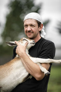 Portrait of young man with goat