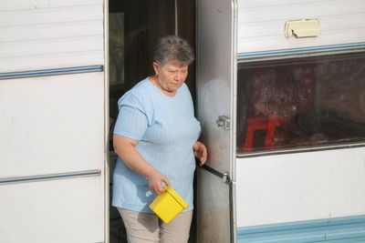 High angle view of woman standing at entrance of camper trailer