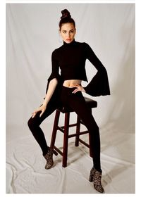 Portrait of young woman sitting against wall