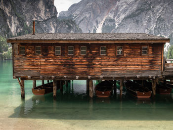 Built structure by sea against mountains