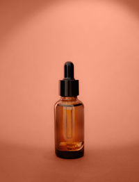  cosmetic bottle serum dark glass, oil cosmetic on calming coral background,  brand packaging 