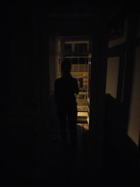 Rear view of silhouette man standing in building