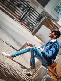 Side view of young man sitting outdoors