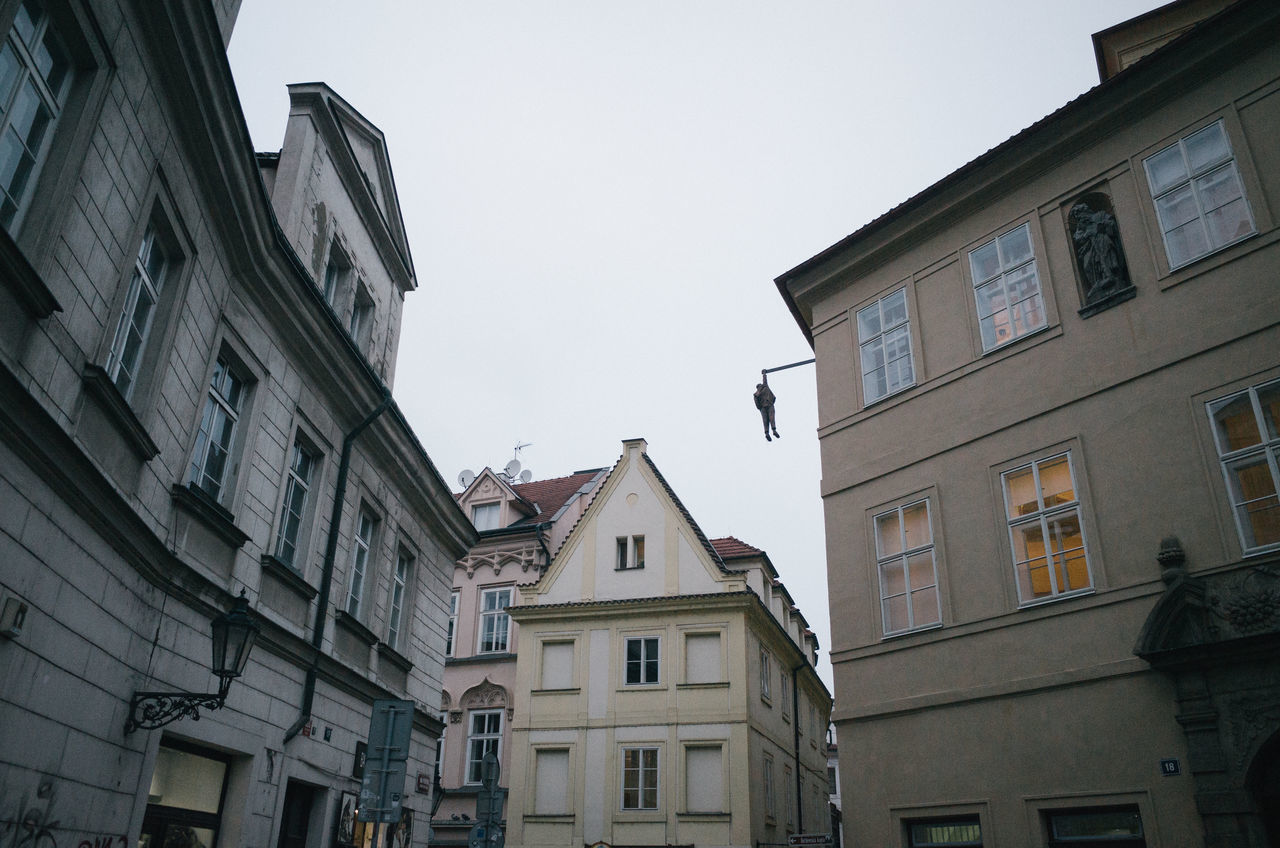 LOW ANGLE VIEW OF BIRD PERCHING ON BUILDINGS