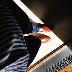 Low section of woman standing on tiled floor