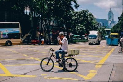 Rear view of man riding bicycle on city street