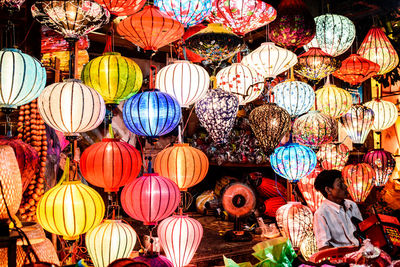 Illuminated lanterns hanging at market stall