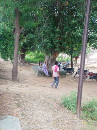 Rear view of people walking on field