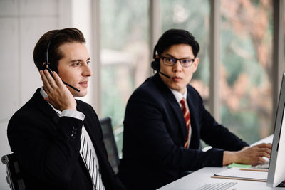 Male coworkers working at desk in office