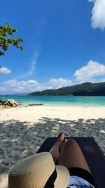 Low section of man relaxing on beach