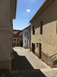 Alley amidst buildings in town during sunny day