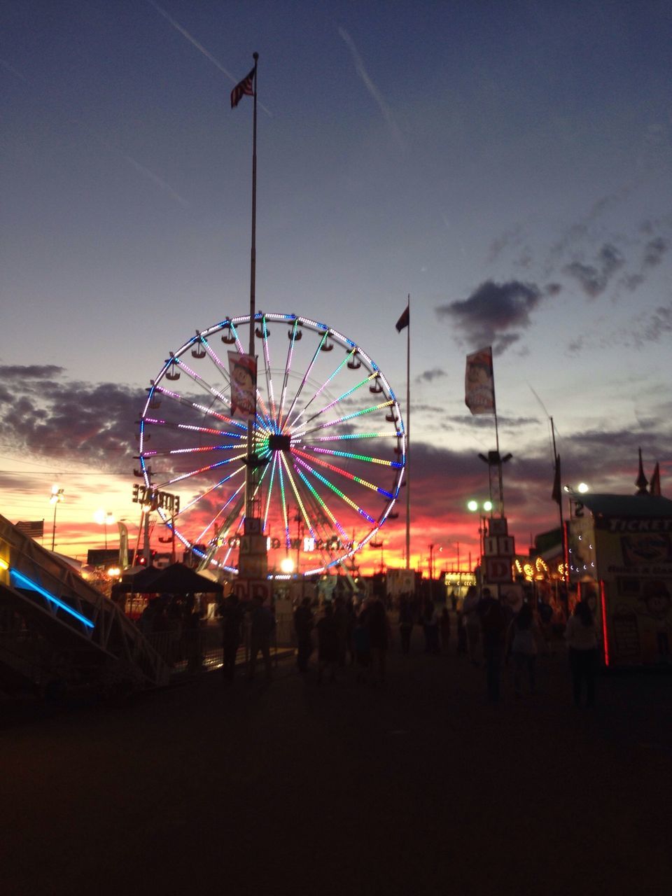 amusement park, arts culture and entertainment, amusement park ride, ferris wheel, sky, leisure activity, enjoyment, fun, large group of people, low angle view, illuminated, lifestyles, silhouette, men, cloud - sky, dusk, chain swing ride, outdoors, person