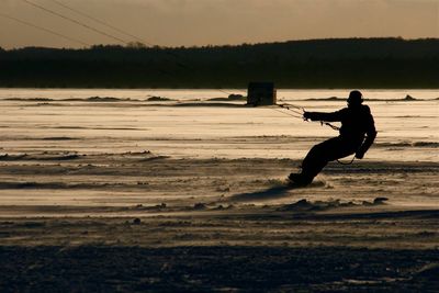 Rear view of silhouette man standing on beach