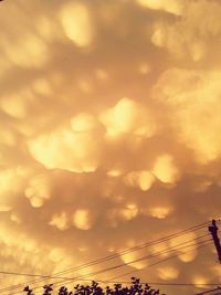 Low angle view of silhouette electricity pylon against sky during sunset