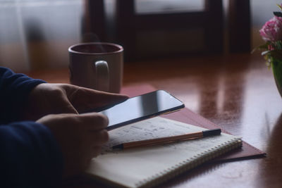 Midsection of coffee cup on table