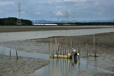 Fisherman by boat at mud flat